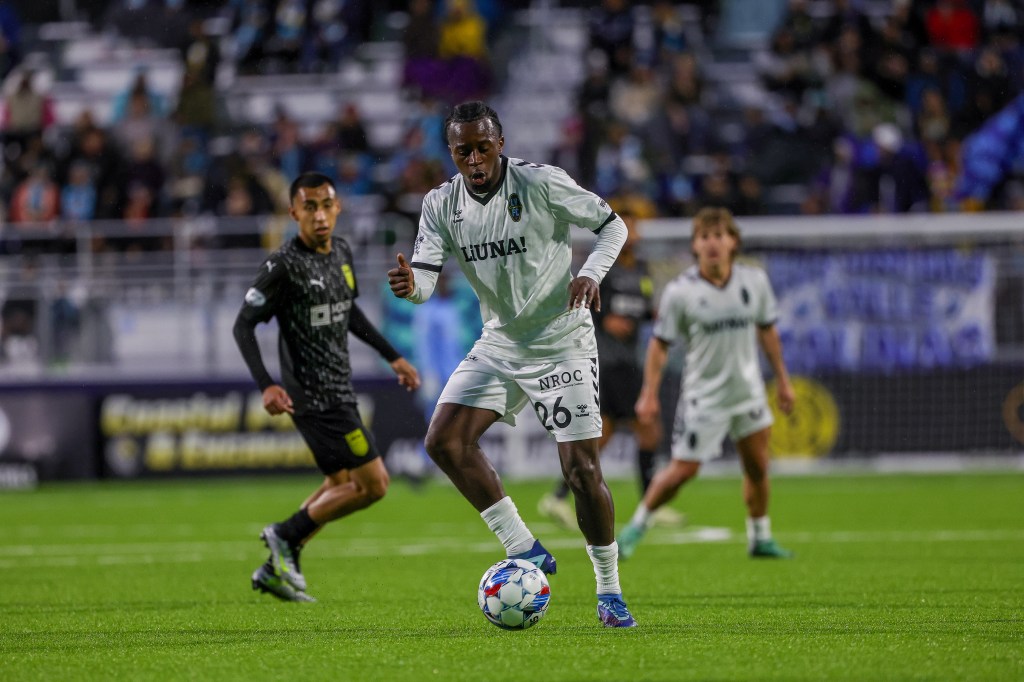 Las Vegas Lights FC midfielder J.C. Ngando dribbling the ball away from a Monterey Bay FC player